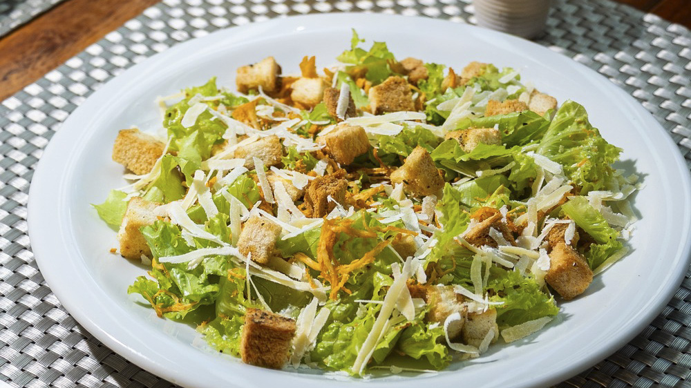 Salada Caesar no jantar | Restaurante Planalto, Rurópolis – PA Salada Caesar com folhas verdes, croutons e lascas de parmesão em prato branco no Restaurante Planalto, em Rurópolis, Pará.